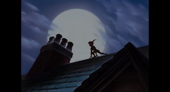 Movie still from “Elizabeth: A Portrait in Part(s)” (2022), directed by Roger Michell – A man standing on top of a roof near a building; Wide shot, Low angle