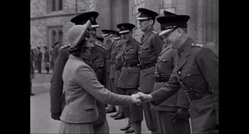 Movie still from “Elizabeth: A Portrait in Part(s)” (2022), directed by Roger Michell – A group of people standing next to each other in uniform; Medium shot, Low angle