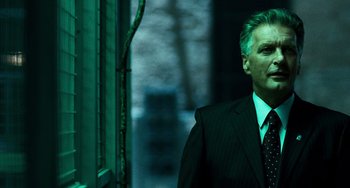 Movie still from “A Good Day to Die Hard” (2013), directed by John Moore – A man wearing a suit and tie standing in front of a window; Close Up shot, Low angle