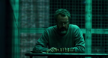 Movie still from “A Good Day to Die Hard” (2013), directed by John Moore – A man sitting in front of a chess board; Medium shot, Over the shoulder angle