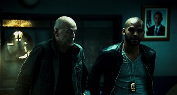 Movie still from “A Good Day to Die Hard” (2013), directed by John Moore – Two men standing next to each other in a dark room; Medium shot, Low angle
