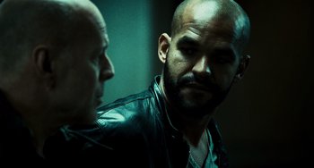 Movie still from “A Good Day to Die Hard” (2013), directed by John Moore – A man with a shaved head is looking at another man with a shaved head; Close Up shot, Over the shoulder angle