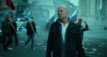 Movie still from “A Good Day to Die Hard” (2013), directed by John Moore – A man in a black jacket is walking in the street; Medium shot, Low angle
