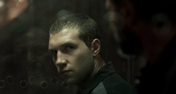 Movie still from “A Good Day to Die Hard” (2013), directed by John Moore – A person in a dark room; Close Up shot, Over the shoulder angle