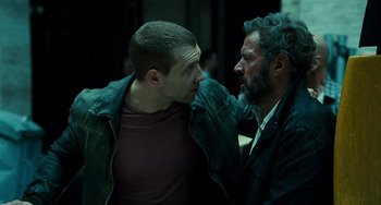 Movie still from “A Good Day to Die Hard” (2013), directed by John Moore – A man and a man with a beard are talking to each other; Medium shot, Over the shoulder angle