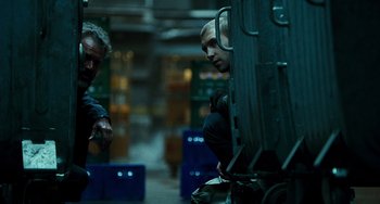 Movie still from “A Good Day to Die Hard” (2013), directed by John Moore – A man sitting on top of a truck next to another man; Medium shot, Low angle