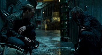 Movie still from “A Good Day to Die Hard” (2013), directed by John Moore – A man sitting on top of a bike in a parking lot; Medium shot, Over the shoulder angle