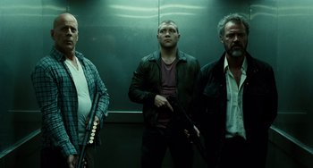 Movie still from “A Good Day to Die Hard” (2013), directed by John Moore – A group of men standing next to each other holding guns; Medium shot, Low angle