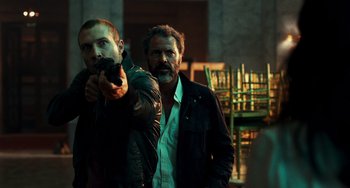 Movie still from “A Good Day to Die Hard” (2013), directed by John Moore – Two men standing next to each other holding a gun; Medium shot, Low angle