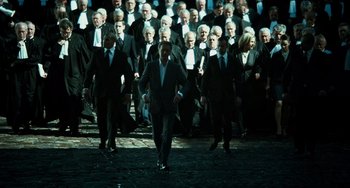 Movie still from “A Good Day to Die Hard” (2013), directed by John Moore – A group of men in suits and ties walking down a street; Wide shot, High angle