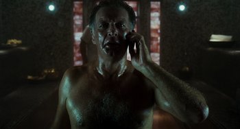 Movie still from “A Good Day to Die Hard” (2013), directed by John Moore – A shirtless man talking on a cell phone in a bathroom; Close Up shot, Low angle