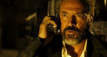 Movie still from “A Good Day to Die Hard” (2013), directed by John Moore – A man with a beard is talking on a cell phone; Close Up shot, Low angle