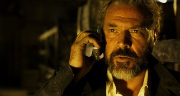 Movie still from “A Good Day to Die Hard” (2013), directed by John Moore – A man with a beard is talking on a cell phone; Close Up shot, Low angle