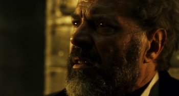 Movie still from “A Good Day to Die Hard” (2013), directed by John Moore – An old man with a beard is looking at the camera; Close Up shot, Over the shoulder angle