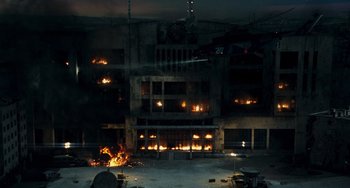 Movie still from “A Good Day to Die Hard” (2013), directed by John Moore – A building that has a lot of fire coming out of it; Extreme Wide shot, High angle
