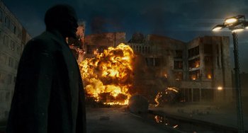 Movie still from “A Good Day to Die Hard” (2013), directed by John Moore – An explosion is seen in the background of a building; Extreme Wide shot, Low angle