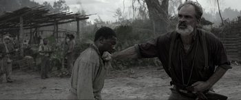 Movie still from “Emancipation” (2022), directed by Antoine Fuqua – Two men in the mud one is choking the other one is choking him; Medium shot, Over the shoulder angle