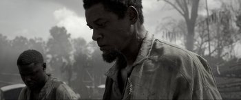 Movie still from “Emancipation” (2022), directed by Antoine Fuqua – A black and white photo of a man with a beard; Close Up shot, Over the shoulder angle