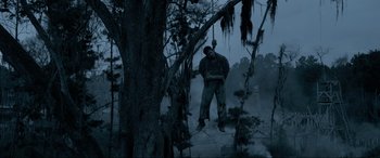 Movie still from “Emancipation” (2022), directed by Antoine Fuqua – A man standing next to a tree in the woods; Wide shot, Low angle
