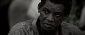 Movie still from “Emancipation” (2022), directed by Antoine Fuqua – An old man with a beard and a mustache looking at the camera; Close Up shot, Over the shoulder angle