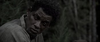 Movie still from “Emancipation” (2022), directed by Antoine Fuqua – A man with a beard is looking at the camera; Close Up shot, High angle