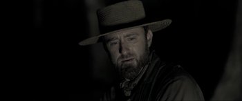 Movie still from “Emancipation” (2022), directed by Antoine Fuqua – A man with a beard wearing a hat; Close Up shot, Over the shoulder angle