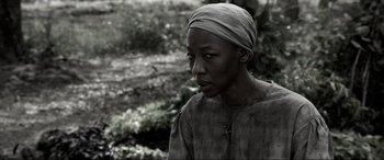 Movie still from “Emancipation” (2022), directed by Antoine Fuqua – A black and white photo of a woman with a headscarf; Close Up shot, Over the shoulder angle