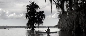Movie still from “Emancipation” (2022), directed by Antoine Fuqua – A man is in a boat in the water; Extreme Wide shot, Low angle