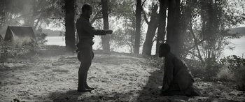 Movie still from “Emancipation” (2022), directed by Antoine Fuqua – A man and a boy in the woods with trees in the background; Wide shot, Over the shoulder angle
