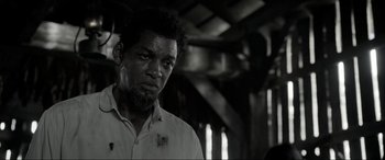 Movie still from “Emancipation” (2022), directed by Antoine Fuqua – A black and white photo of a man in a white shirt; Close Up shot, Over the shoulder angle