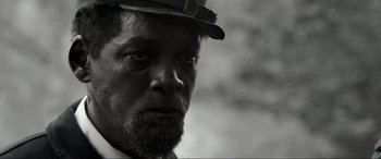 Movie still from “Emancipation” (2022), directed by Antoine Fuqua – A black and white photo of a man with a hat on; Close Up shot, Over the shoulder angle