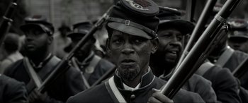 Movie still from “Emancipation” (2022), directed by Antoine Fuqua – A group of men in uniforms are standing together; Close Up shot, Over the shoulder angle