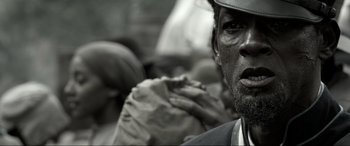 Movie still from “Emancipation” (2022), directed by Antoine Fuqua – A man's face in a crowd of people; Extreme Close Up shot, Over the shoulder angle