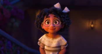 Movie still from “Encanto” (2021), directed by Charise Castro Smith – A girl with glasses is smiling for the camera; Medium shot, Low angle