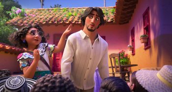 Movie still from “Encanto” (2021), directed by Charise Castro Smith – A man in a white shirt is standing next to a woman; Medium shot, Over the shoulder angle