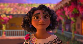 Movie still from “Encanto” (2021), directed by Charise Castro Smith – A woman with curly black hair wearing glasses and a white dress; Close Up shot, Low angle