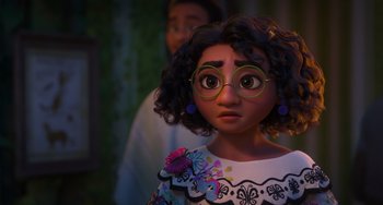 Movie still from “Encanto” (2021), directed by Charise Castro Smith – A young girl wearing glasses and a colorful dress; Close Up shot, Over the shoulder angle