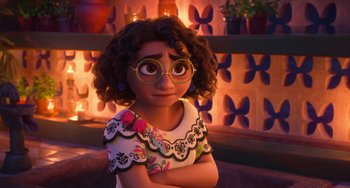 Movie still from “Encanto” (2021), directed by Charise Castro Smith – A young girl wearing glasses with her arms crossed; Close Up shot, Over the shoulder angle