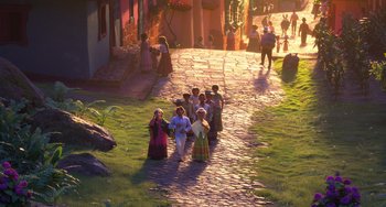 Movie still from “Encanto” (2021), directed by Charise Castro Smith – A group of people walking down a brick path; Extreme Wide shot, High angle