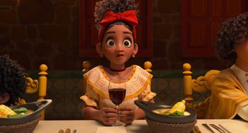 Movie still from “Encanto” (2021), directed by Charise Castro Smith – A woman sitting at a table holding a glass of wine; Close Up shot, Over the shoulder angle