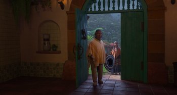 Movie still from “Encanto” (2021), directed by Charise Castro Smith – Two people standing in front of an open door; Wide shot, Over the shoulder angle