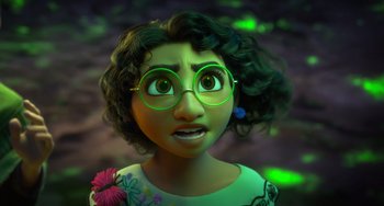Movie still from “Encanto” (2021), directed by Charise Castro Smith – An animated woman with glasses is looking at the camera; Close Up shot, Over the shoulder angle