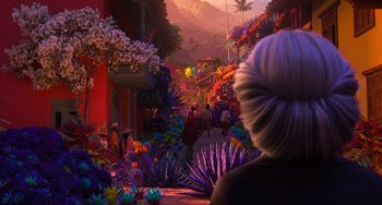 Movie still from “Encanto” (2021), directed by Charise Castro Smith – An image of a woman looking out at a colorful scene; Wide shot, Over the shoulder angle