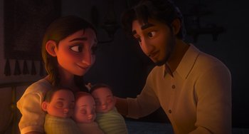 Movie still from “Encanto” (2021), directed by Charise Castro Smith – A man and a woman holding two babies in their arms; Medium shot, Overhead angle