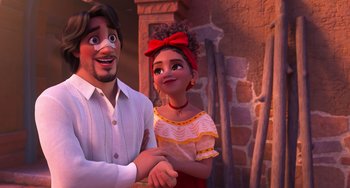 Movie still from “Encanto” (2021), directed by Charise Castro Smith – A man and a woman standing next to each other in front of a brick wall; Medium shot, Over the shoulder angle