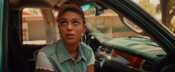 Movie still from “End of the Road” (2022), directed by Millicent Shelton – A young woman sitting in a car looking out of the window; Close Up shot, Over the shoulder angle