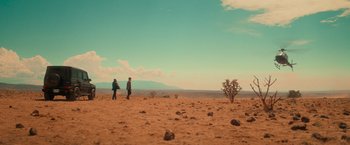 Movie still from “End of the Road” (2022), directed by Millicent Shelton – Two people are standing in the desert looking at the sky; Extreme Wide shot, Low angle