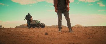 Movie still from “End of the Road” (2022), directed by Millicent Shelton – A man standing in the middle of the desert; Wide shot, Low angle