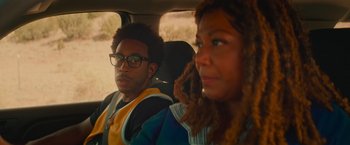 Movie still from “End of the Road” (2022), directed by Millicent Shelton – A man and a woman sitting in the back of a car; Close Up shot, Over the shoulder angle