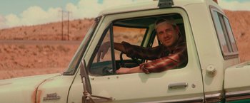 Movie still from “End of the Road” (2022), directed by Millicent Shelton – A man sitting in the driver's seat of a truck; Medium shot, Over the shoulder angle